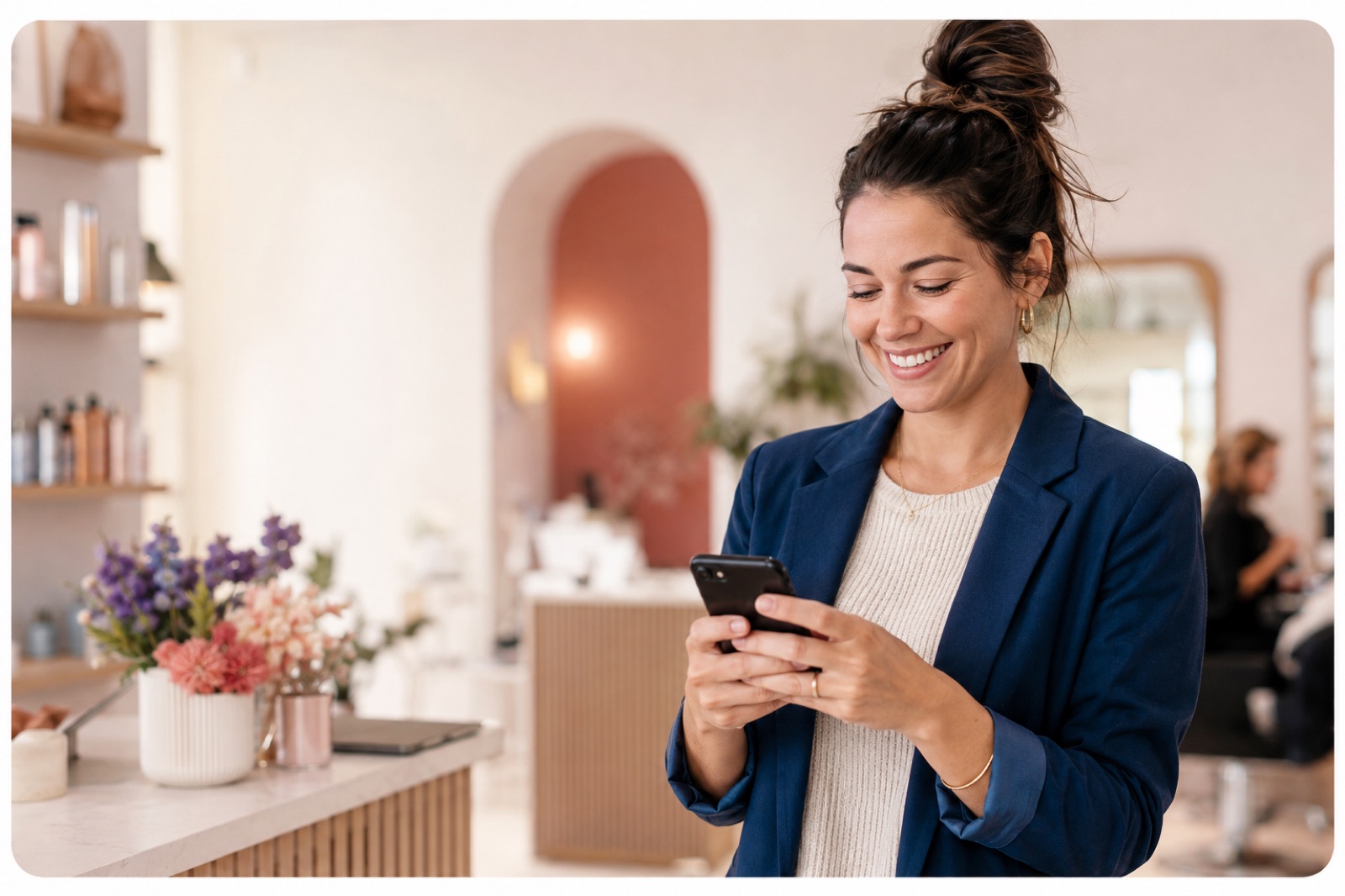 A happy business owner checking her phone in a bright studio